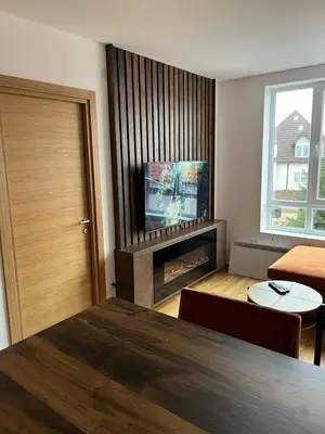 a room with a television and a living room with a table at Apartman Sofy Kraljevi Čardaci in Kopaonik