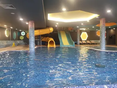 a large swimming pool with a slide in a hotel room at Apartman Sofy Kraljevi Čardaci in Kopaonik