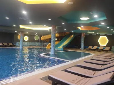 a swimming pool with a slide in a hotel room at Apartman Sofy Kraljevi Čardaci in Kopaonik