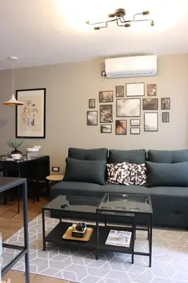 a living room with a blue couch and a table at Vista Apartmani in Ribarska Banja