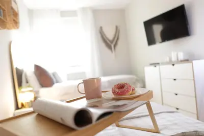 a table with a plate of donuts and a cup of coffee at Vista Apartmani in Ribarska Banja