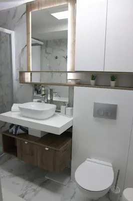 a bathroom with a sink and a toilet and a mirror at Vista Apartmani in Ribarska Banja
