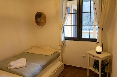a small bedroom with a bed and a window at Apartman TALIJA in Pirot