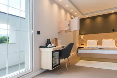 a bedroom with a bed and a desk with a computer at Emilia Lux Rooms in Vrnjačka Banja