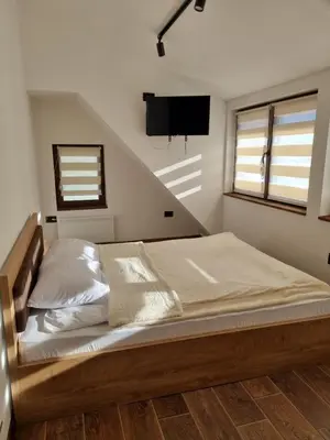 a bedroom with a bed with a tv on the wall at Garnet Star Apartments, Kopaonik, apartman broj 4 in Kopaonik