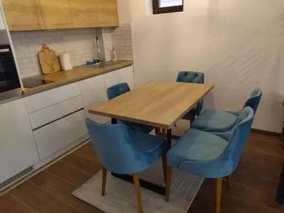 a kitchen with a wooden table and blue chairs at Garnet Star Apartments, Kopaonik, apartman broj 4 in Kopaonik