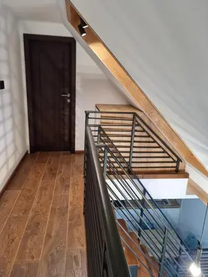 a staircase with a wooden floor and a black door at Garnet Star Apartments, Kopaonik, apartman broj 4 in Kopaonik