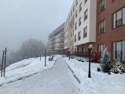 a street covered in snow next to a building at Apartman Stankovic Milmari Resort in Kopaonik