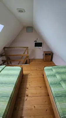a attic room with two beds and a tv at Apartman 202 in Kopaonik