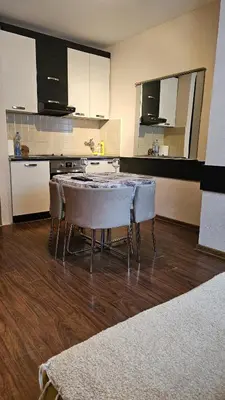 a kitchen with a table and chairs in a room at Apartman 202 in Kopaonik