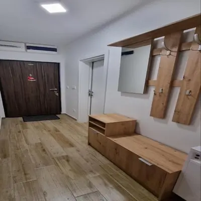an empty room with a kitchen with wooden floors and a door at Iznad oblaka B09 in Kopaonik