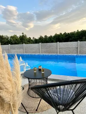 a patio with a table and chairs next to a swimming pool at Mi Casa in Brestovac