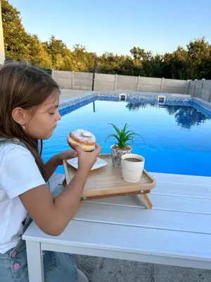 a little girl sitting at a table eating a sandwich at Mi Casa in Brestovac