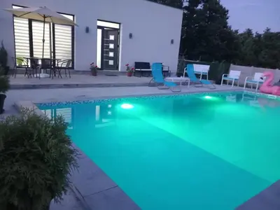 a swimming pool with blue lighting in a backyard at Mi Casa in Brestovac