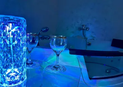 three wine glasses sitting on a table next to a bath tub at Mi Casa in Brestovac