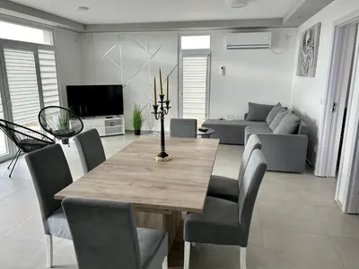 a living room with a wooden table and chairs at Mi Casa in Brestovac