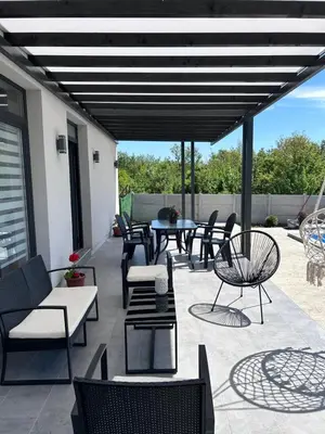 a patio with a bunch of chairs and tables at Mi Casa in Brestovac