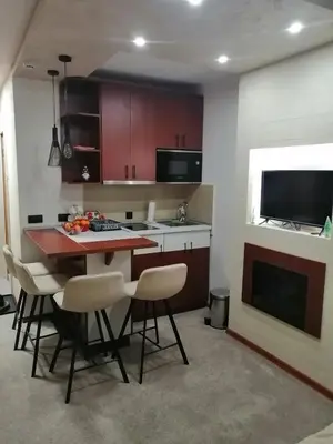 a kitchen with a table and chairs and a television at Tina Kop Apartments, Kopaonik in Kopaonik