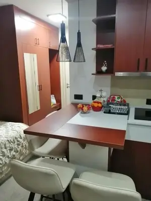 a kitchen with a table with two chairs and a counter top at Tina Kop Apartments, Kopaonik in Kopaonik