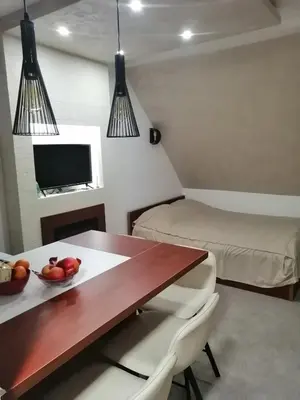 a room with a dining table and a bed at Tina Kop Apartments, Kopaonik in Kopaonik