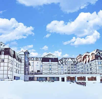 a large building with snow in front of it at Apartmani BOŠ in Cajetina