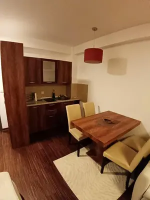 a living room with a wooden table and chairs at Apartmani BOŠ in Cajetina