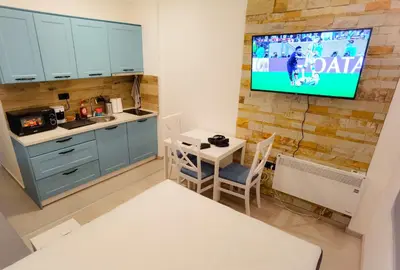 a kitchen with a table and a tv on a wall at Apartman Rastko-N Lux 32 Milmari in Kopaonik