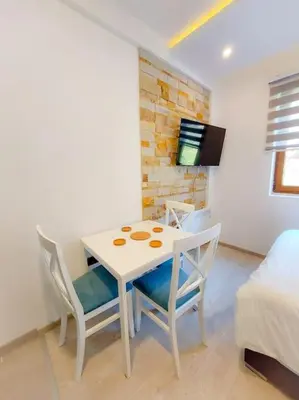 a room with a table and chairs and a bed at Apartman Rastko-N Lux 32 Milmari in Kopaonik