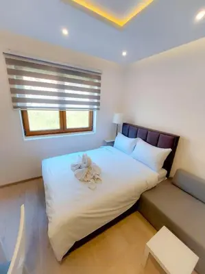a bedroom with a large white bed with a window at Apartman Rastko-N Lux 32 Milmari in Kopaonik