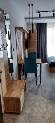 a room with a desk and a table and chairs at Nela apartmani (u hotelu Djina) in Kopaonik