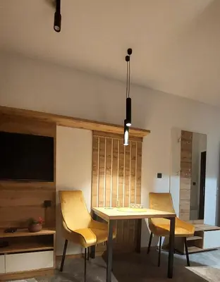 a dining room with a table and two chairs at Nela apartmani (u hotelu Djina) in Kopaonik