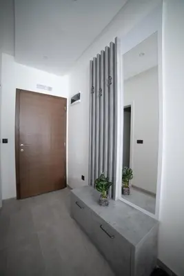 a hallway with a mirror and a wooden door at NLux 11 Apartment in Kopaonik
