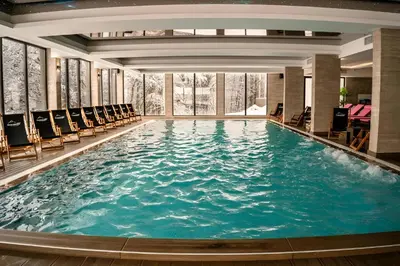 a large swimming pool in a hotel with chairs at NLux 11 Apartment in Kopaonik