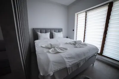 a bedroom with a white bed with two towels on it at NLux 11 Apartment in Kopaonik