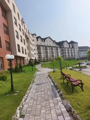 two benches in a park in front of a building at Milmari Apartments Pahulja N Lux in Kopaonik