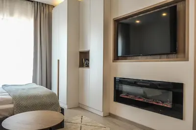 a living room with a flat screen tv above a fireplace at Milmari Apartments Pahulja N Lux in Kopaonik