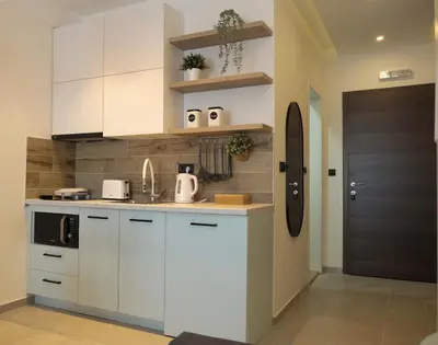 a kitchen with white cabinets and a sink at Milmari Apartments Pahulja N Lux in Kopaonik