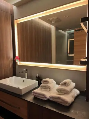 a bathroom with a sink and a mirror and towels at Woodside Story in Kopaonik