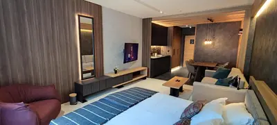 a bedroom with a bed and a living room at Woodside Story in Kopaonik