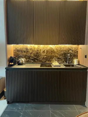 a kitchen with a black counter with a sink at Woodside Story in Kopaonik
