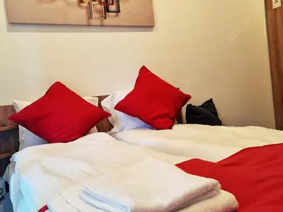 two beds with red pillows sitting next to each other at Nest studio Milmari Kopaonik in Kopaonik