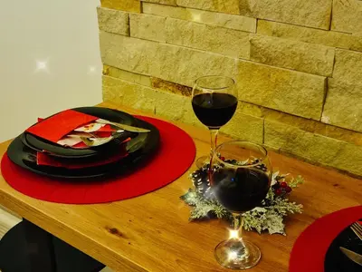 a table with two glasses of wine and a plate of food at Nest studio Milmari Kopaonik in Kopaonik