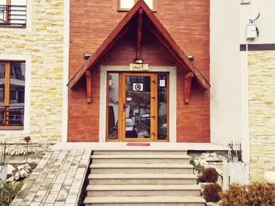 a house with wooden doors and stairs in front of it at Nest studio Milmari Kopaonik in Kopaonik