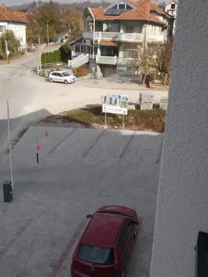 a red car is parked in a parking lot at Apartman Katarina in Soko Banja