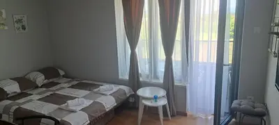 a bedroom with a bed and a table and a window at Apartman Katarina in Soko Banja