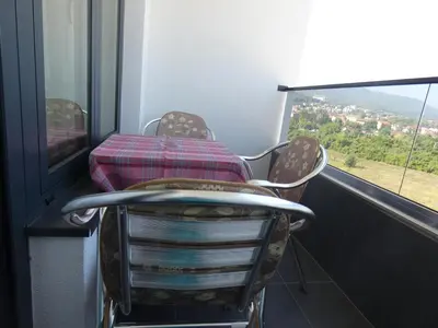 a chair in a room with a table and a window at Apartman Katarina in Soko Banja