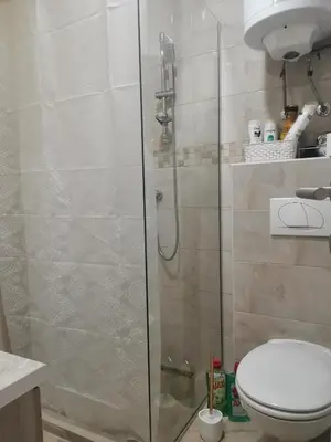 a bathroom with a toilet and a glass shower stall at BELVEDERE A9 ( N LUX MILMARI RESORT) in Kopaonik