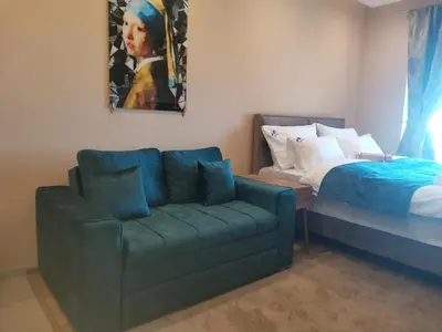 a living room with a couch and a bed at BELVEDERE A9 ( N LUX MILMARI RESORT) in Kopaonik