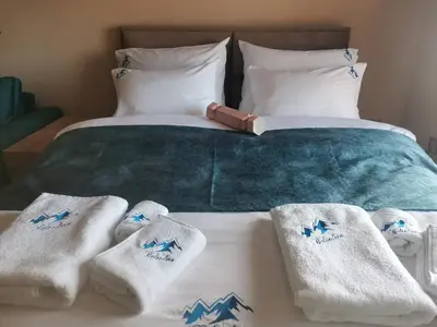 a bed with white towels and mountains on it at BELVEDERE A9 ( N LUX MILMARI RESORT) in Kopaonik