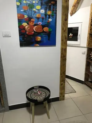 a table in a room with a painting on the wall at APARTMAN Pahuljica in Kruševac